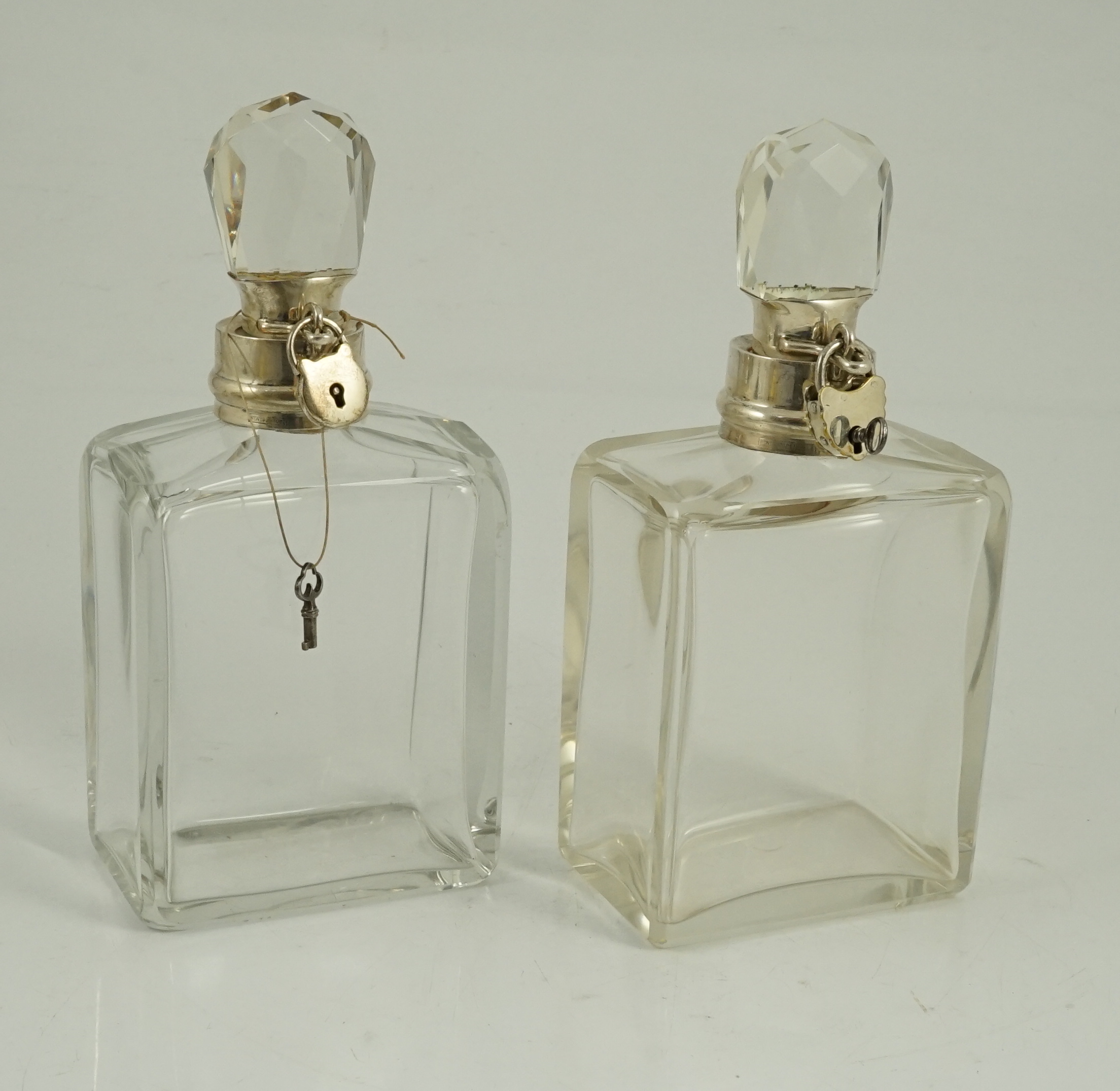 A pair of George V Hukin & Heath silver mounted glass lockable decanters and stoppers, with padlock and key